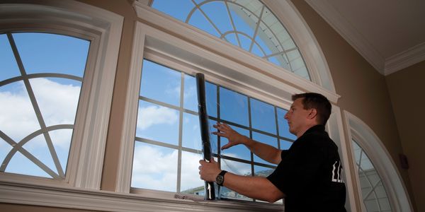 Installer applying architectural film to a large arched window